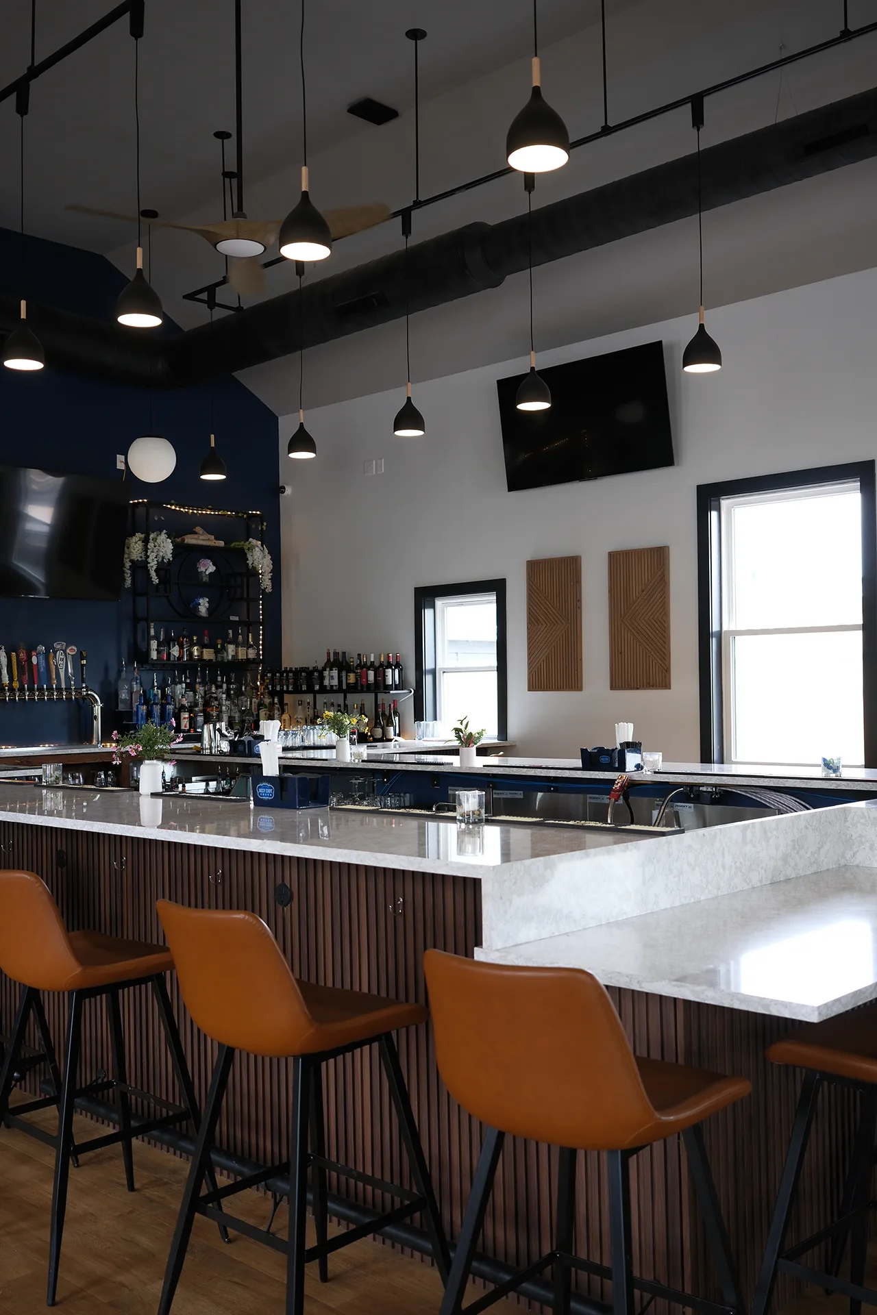 The bar at Fenimore's Table, with tan leather stools, a pale stone-look counter, beer taps and shelves of bottles The bar at Fenimore's Table, with tan leather stools, a pale stone-look counter, beer taps and shelves of bottles
