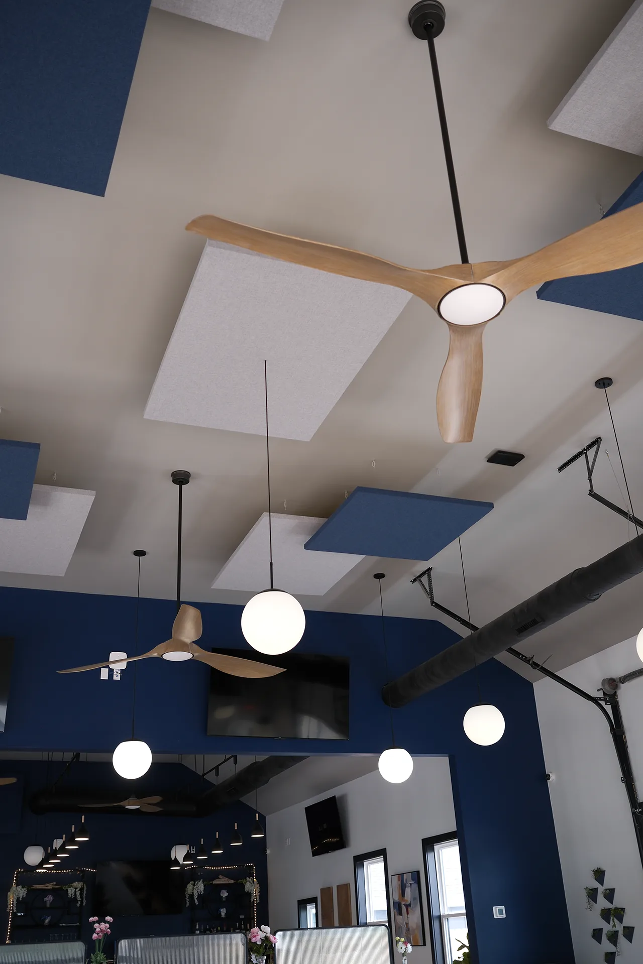 The ceiling at Fenimore's Table, with wood-blade fans, globe pendant lights and blue and white acoustic panels The ceiling at Fenimore's Table, with wood-blade fans, globe pendant lights and blue and white acoustic panels