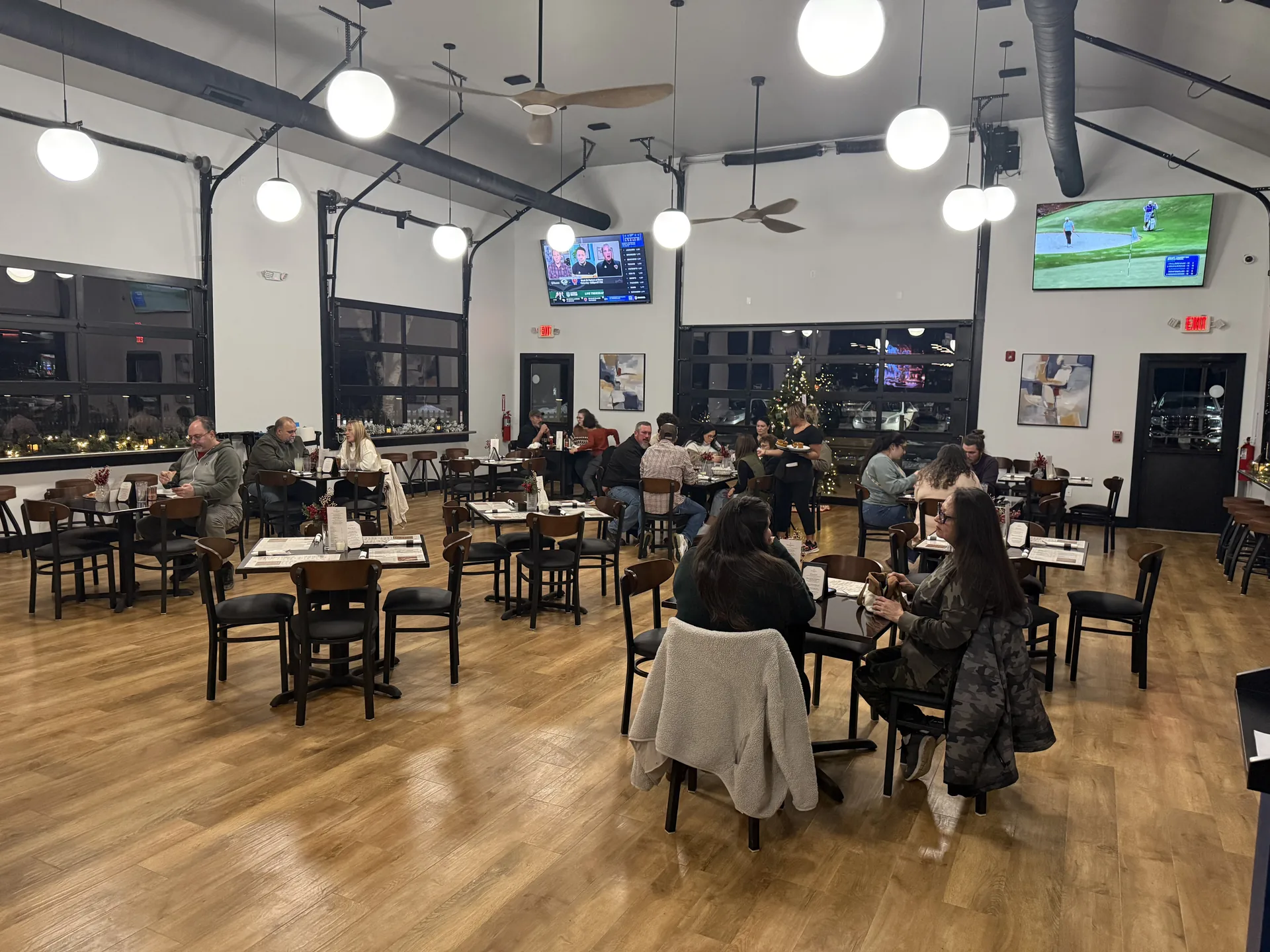 Guests at tables in the main room at Fenimore's Table, with glass garage-style doors, ceiling fans and a Christmas tree Guests at tables in the main room at Fenimore's Table, with glass garage-style doors, ceiling fans and a Christmas tree